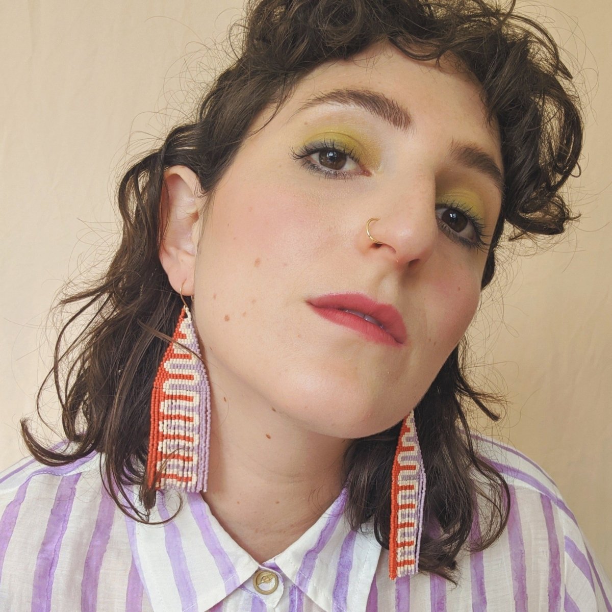 Woven red, white and pastel purple beaded fringe earrings. Designed and handmade by Take Shape studio in Berkeley, California.