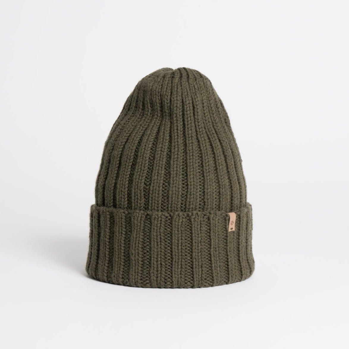 A dark green cuffed hat with thick ribbed design and decrease detail at the top. The Merino Thick Rib Hat in Olive Green is designed by Dinadi and hand knitted in Kathmandu, Nepal.