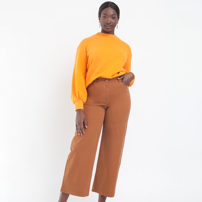 Model wears cropped wide leg jeans in Tan. The Toni Jeans in Tan are designed by Loup and made in New York City, USA.