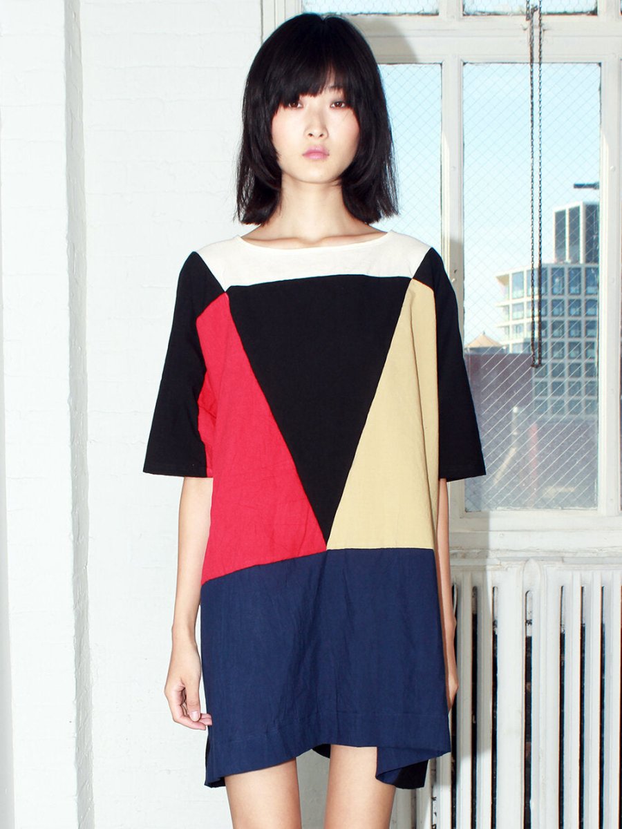 Red, blue, black, white and pale yellow colored tunic style dress with color-blocked triangle design. Designed and sewn by Uzi in Brooklyn, New York.