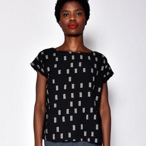 Black short sleeve tunic with faded white square pattern. Designed and sewn by UZI in Brooklyn, New York.