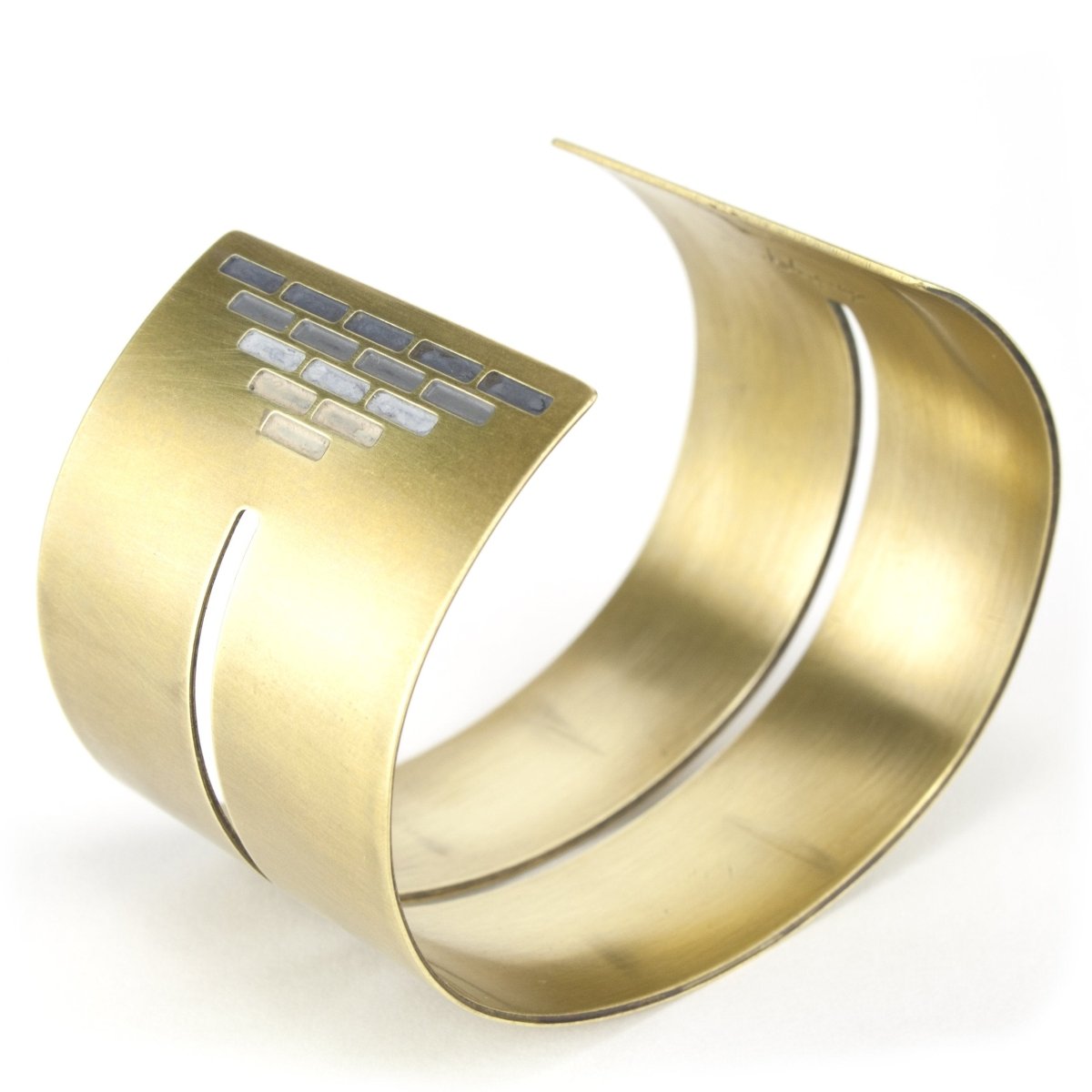 Wide, bold, brass cuff bracelet in the Portland colorway, with a cutout slit that runs through the center of the cuff and stops just short of a pyramid of grayscale paint on either end. Hand-crafted in Portland, Oregon.