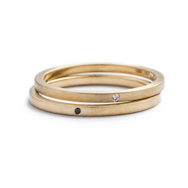 A pair of 14k yellow gold, white and black diamond, betsy & iya Vis Rings. Hand-crafted in Portland, Oregon.