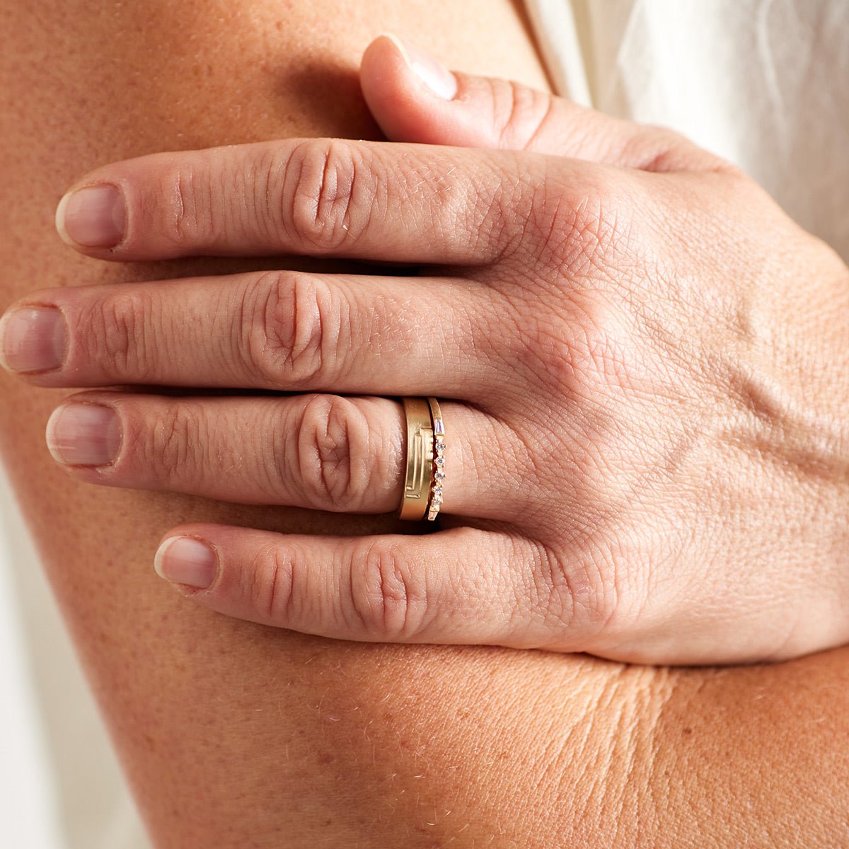Model wears the Alma ring stacked with the Vitae ring.