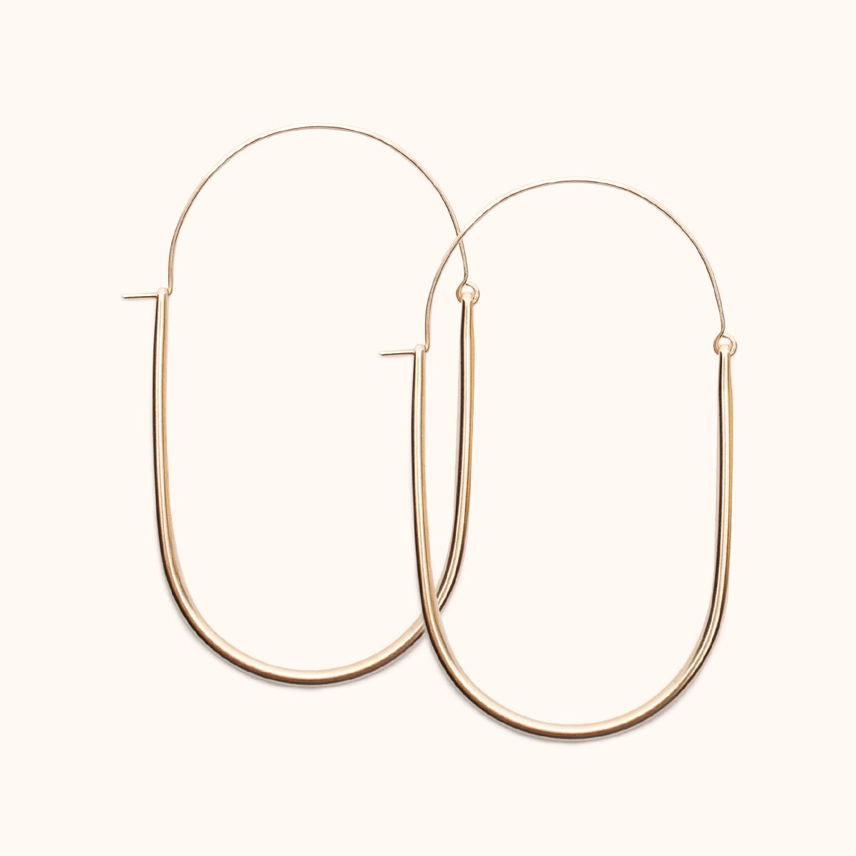 A large gold-fill U-shaped earring with an arched ear wire that meets the top of the U. Designed and handcrafted in Portland, Oregon.