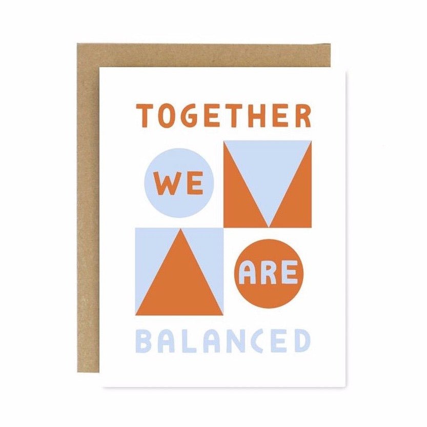 A white card with blue and red contrasting shapes. Front of card reads: "TOGETHER WE ARE BALANCED." Designed and handcrafted by Worthwhile Paper in Ypsilanti, MI.