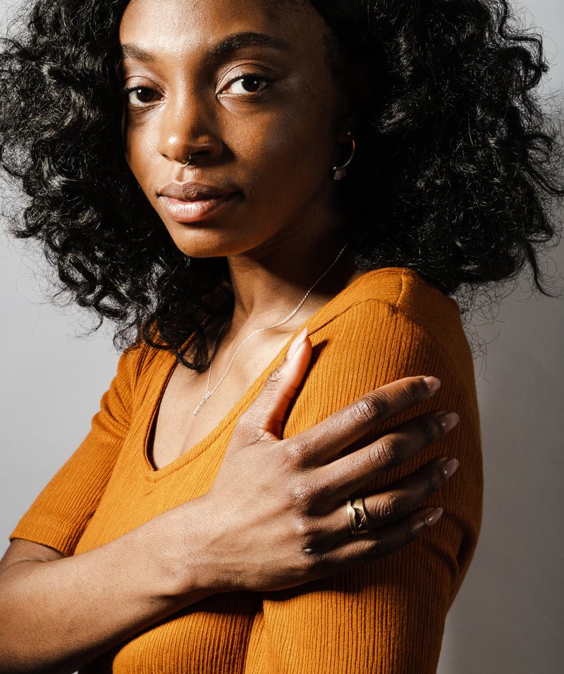 The bronze Willamette ring, styled on a model with a sterling silver betsy & iya Amare necklace and an ochre dress.