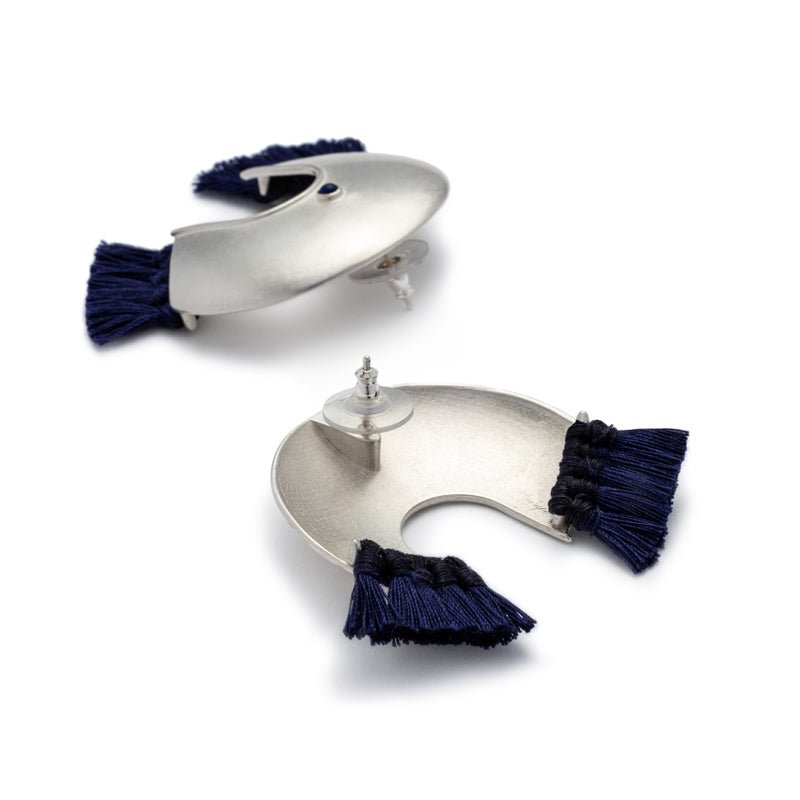 Oversized, arc-shaped silver earrings with navy cotton fringe, ethically sourced and fair trade lapis lazuli, sterling silver earring posts, and sterling silver and plastic comfort-clutch backings. Hand-crafted in Portland, Oregon.