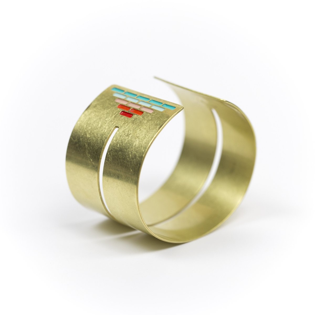 Wide, bold, brass cuff bracelet in the Mexico colorway, with a cutout slit that runs through the center of the cuff and stops just short of a pyramid of rich teal and red paint on either end. Hand-crafted in Portland, Oregon.