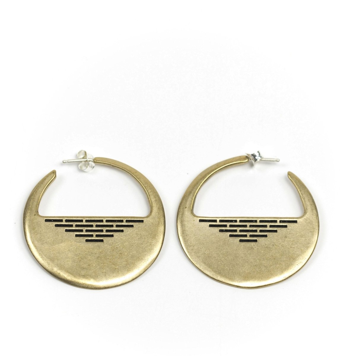 A pair of cast-bronze disc hoop earrings, decorated with a pyramid of geometric, black paint detail through the center of the disc, and finished with sterling silver posts and butterfly backings. Hand-crafted in Portland, Oregon.