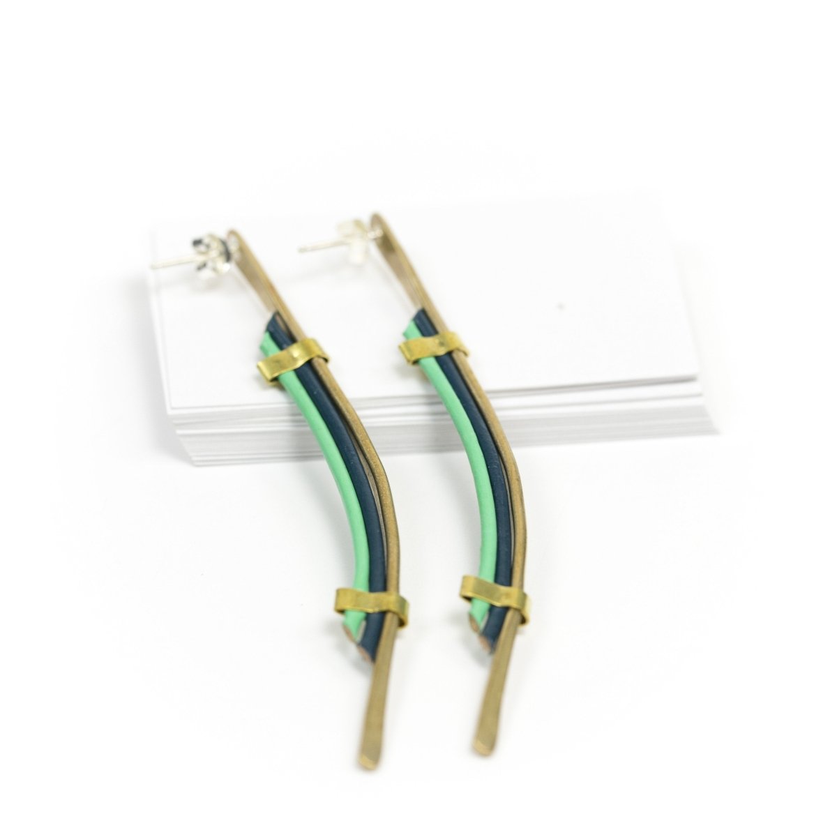 Long brass silver post earrings with blue leather accents.