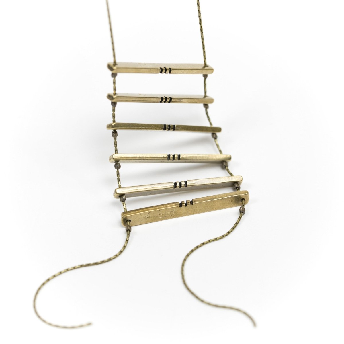 Six cast-bronze bars with black, painted notch details, strung together in the shape of a ladder with a long, clasp-less, brass chain. Hand-crafted in Portland, Oregon.