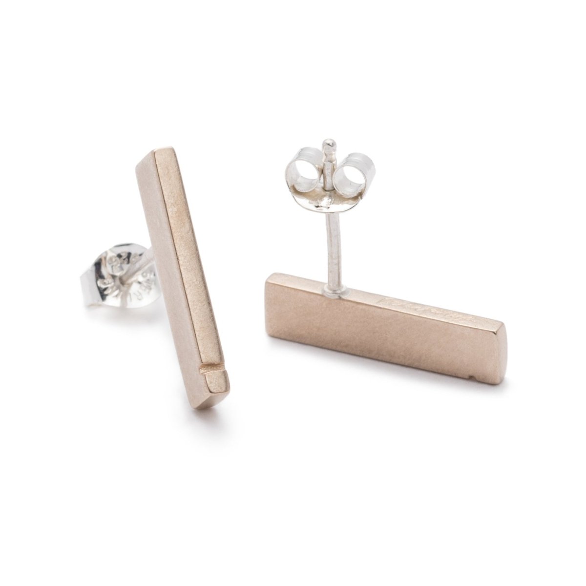 Slim, rectangular bronze bars with a notch detail at one end, soldered to sterling silver earring posts, and finished with sterling silver butterfly earring backings. Hand-crafted in Portland, Oregon.