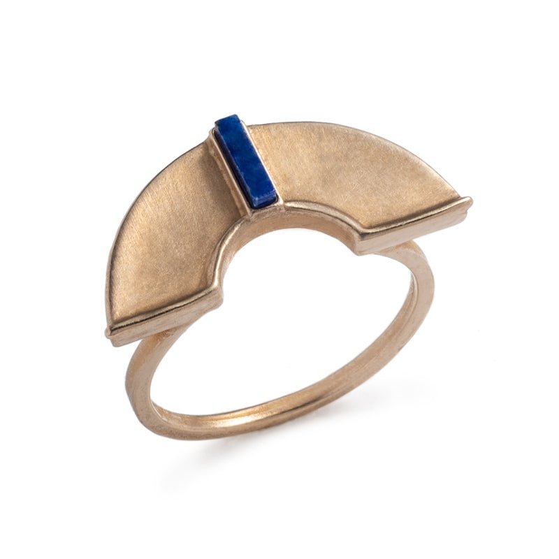 A unique, cast-bronze, half-circle shield, set atop a bronze band, and inlaid with a rectangular, blue, lapis lazuli stone. Hand-crafted in Portland, Oregon.