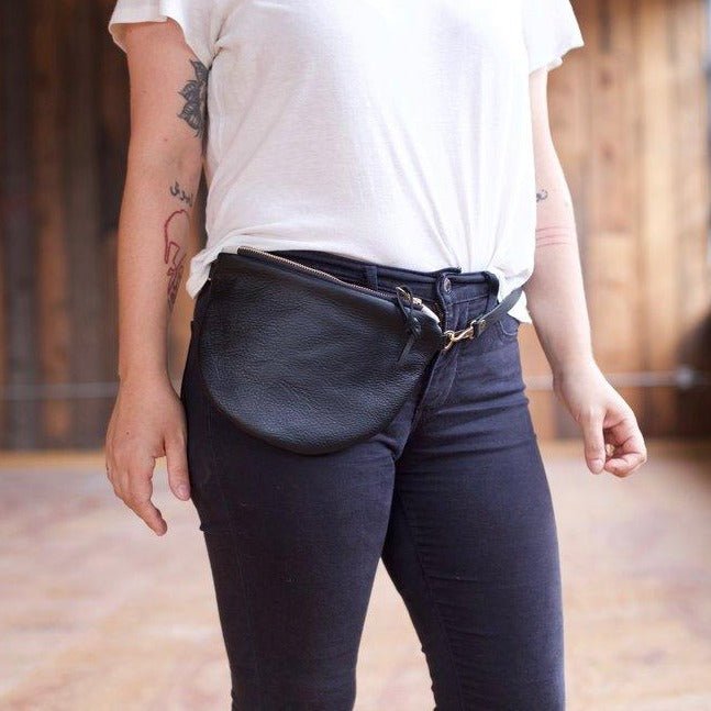 Black leather fanny pack wrapped around someone's waist. Crafted by hand by Frankie & Coco in Portland, Oregon.