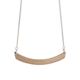 Minimal, curved, cast-bronze pendant, affixed to a sterling silver chain, with a hand-formed sterling silver clasp and closure. Hand-crafted in Portland, Oregon.