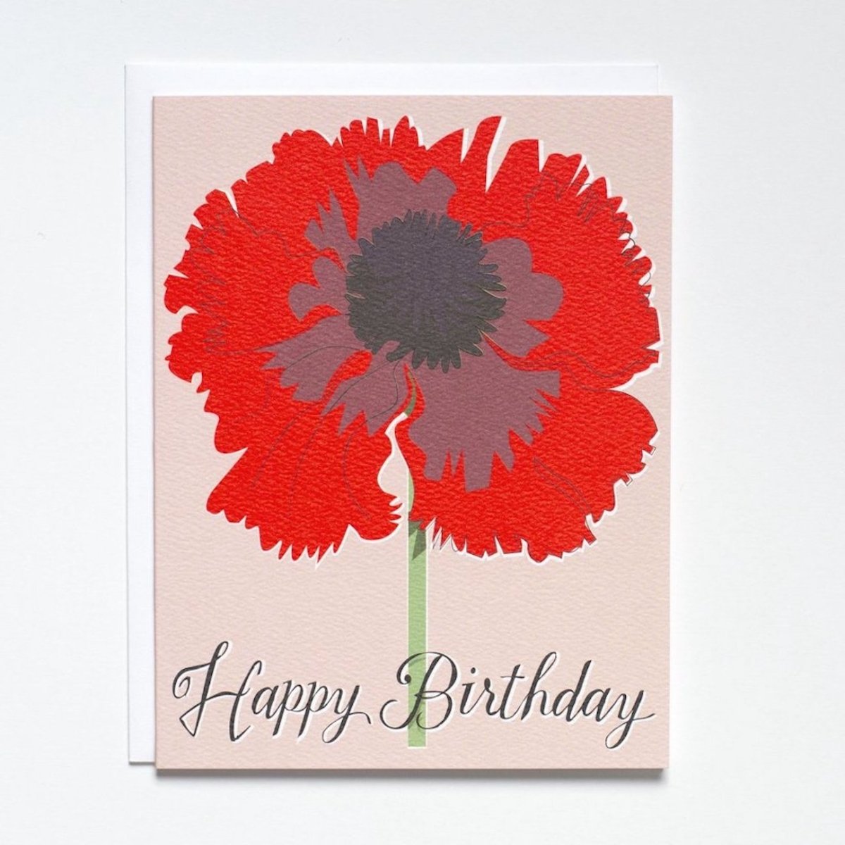 Beautiful bright red poppy against a pale pink background. Bottom of card reads: "HAPPY BIRTHDAY" in grey script. Made with recycled paper by Banquet Atelier in Vancouver, British Columbia, Canada.
