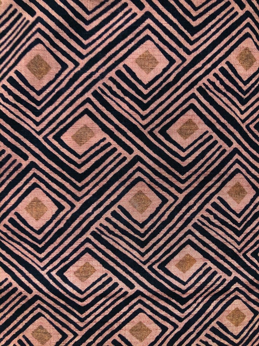 A closeup of the Rumi Bandana. A hand block printed pattern on pink cotton, made in India and designed in Portland, Oregon.