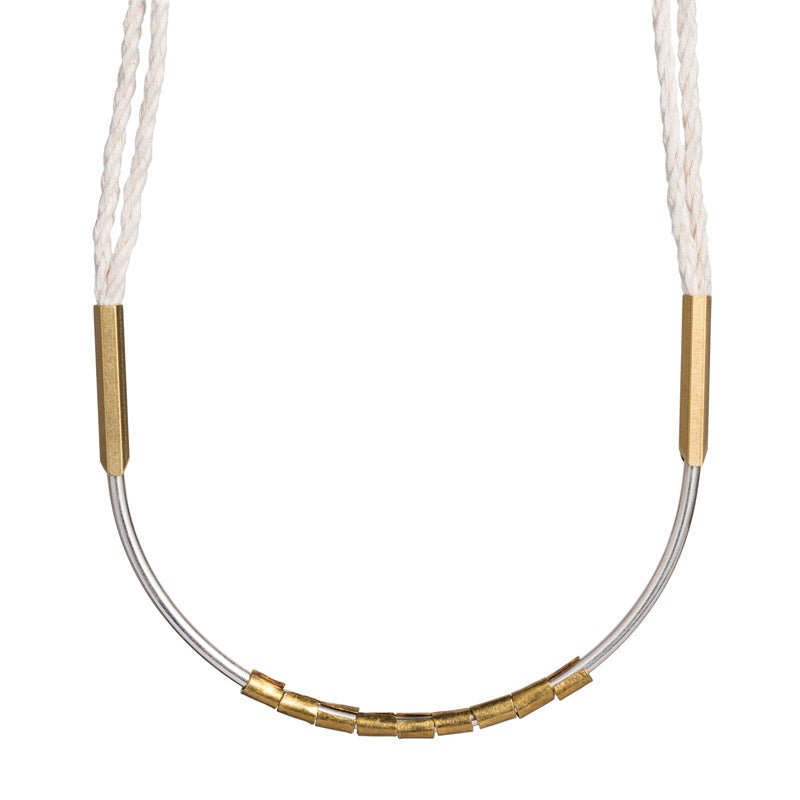 Lightweight, textural statement necklace, featuring cream-colored, hand-spun Japanese cotton rope, a curved, sterling silver focal point, African brass trade beads, and brass fittings. Hand-formed in Portland, Oregon.
