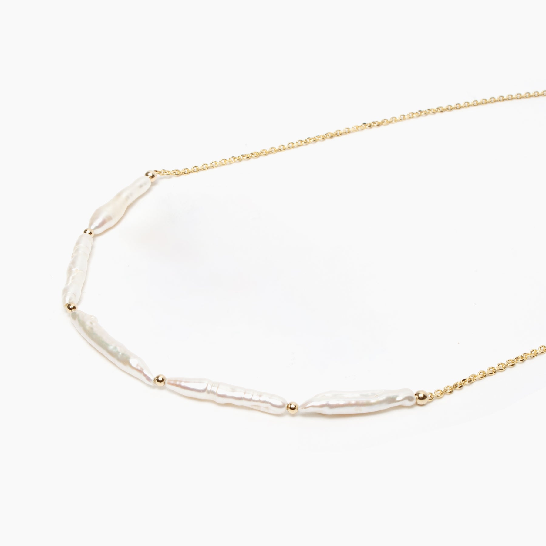 Gold necklace with pearl beads on a white background