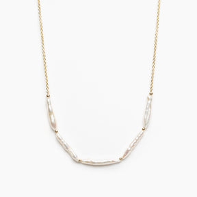 Gold necklace with five stick pearl beads on a white background