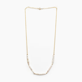 Gold necklace with pearl beads on a white background