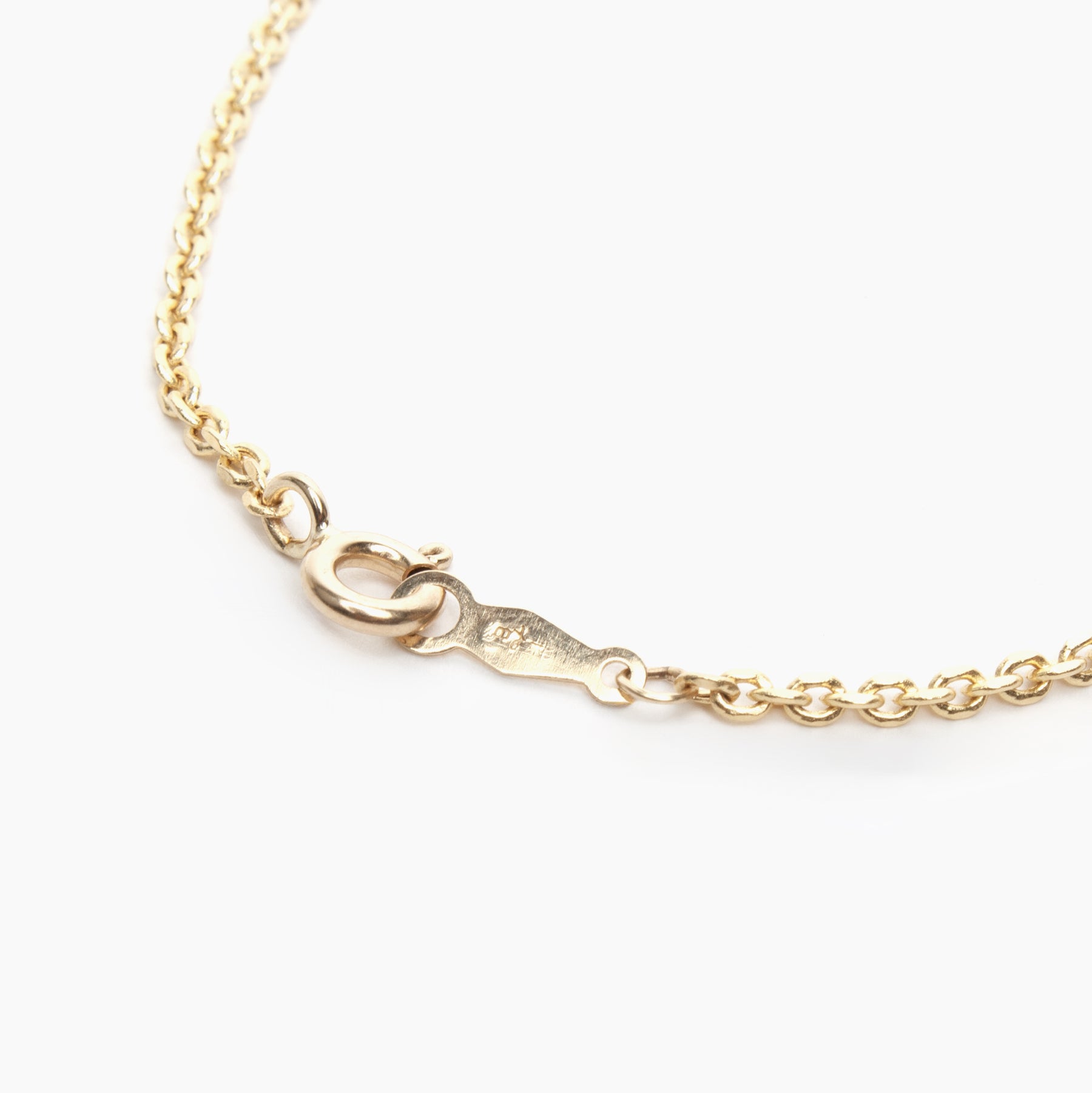 Back of a gold chain necklace on a white background