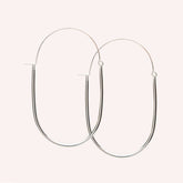 A large sterling silver U-shaped earring with an arched ear wire that meets the top of the U. Designed and handcrafted in Portland, Oregon.