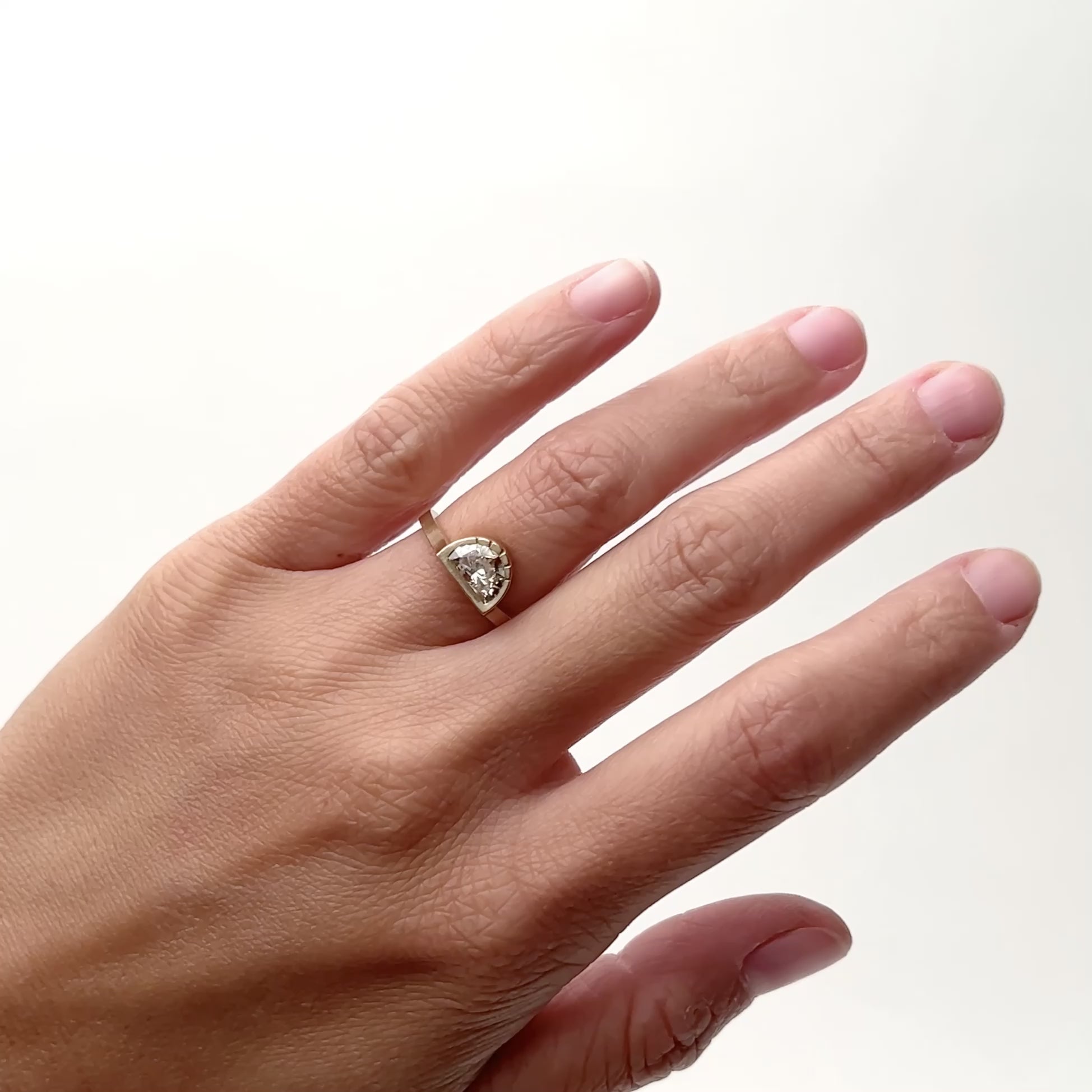 A narrow 14k yellow gold ring featuring a bezel set lab grown white diamond in a semi-circle design. Five etched lines detail the round portion of the ring. Designed and handcrafted in Portland, Oregon.