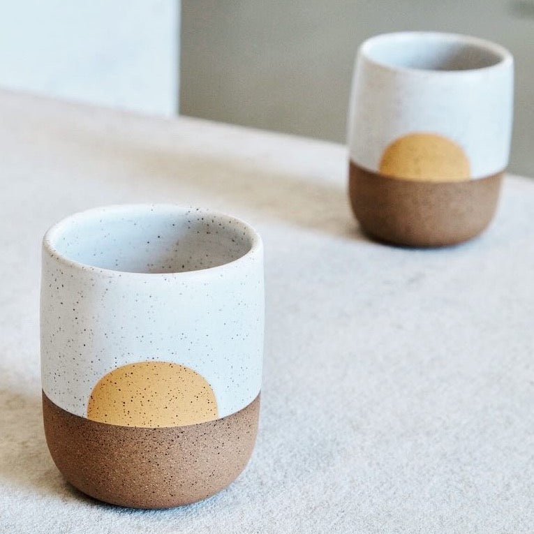 Speckled stoneware handless mug with a white satin glaze collar and yellow concentric design. Designed and hand thrown by Wolf ceramics in Portland, Oregon.
