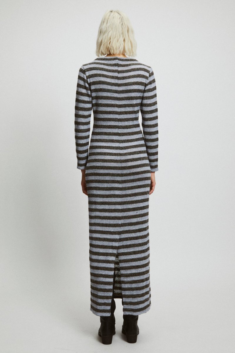 A model shows the backside of a long sleeve dark gray and light gray dress. The back features a slit on the very bottom of the dress. The Alice Dress in Stripes is designed by Rita Row and made in Girona, Spain.