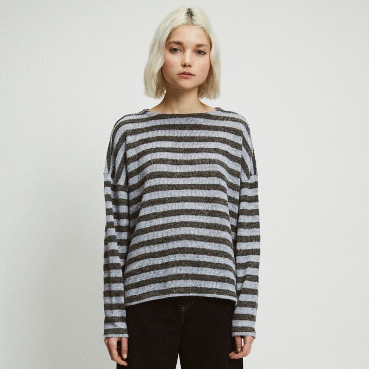 A model wears a light blue and dark ray striped sweater. The Etta Sweater in Stripes is designed by Rita Row and made in Girona, Spain.