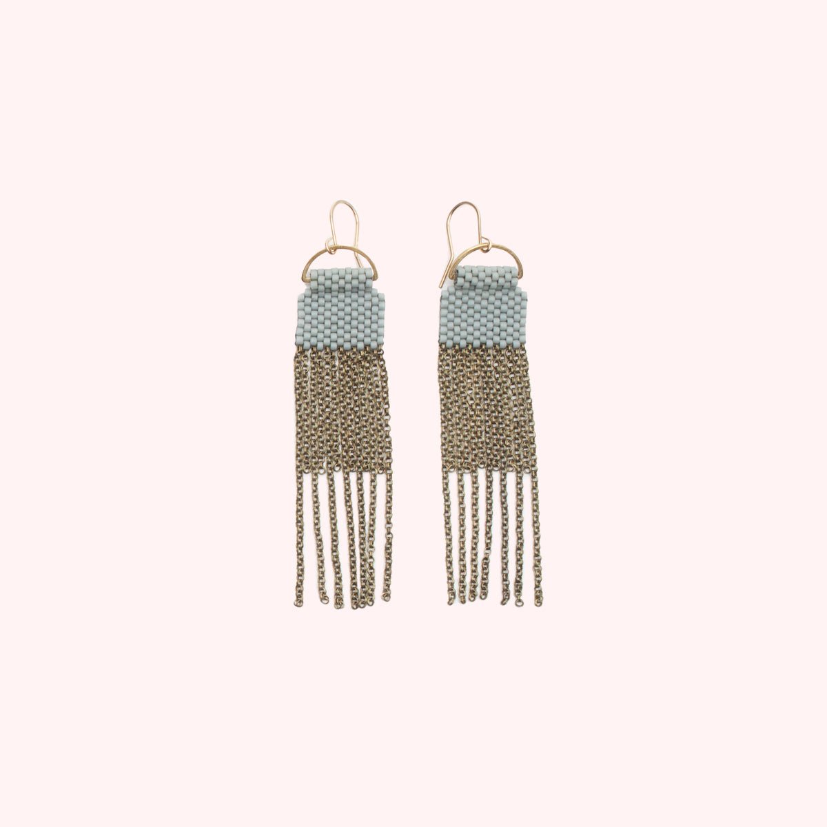 A pair of blue/grey beaded earrings with long strands of antique brass chain secured around a small brass hoop. The Curtain Earrings in Blue Grey are designed and handcrafted by A Nod to Design in Portland, OR.