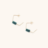 Geometric shaped wire hoop earrings with a small wrapping of teal beads. The Wire Earrings in Dark Teal are designed and handmade by A Nod To Design in Portland, OR.