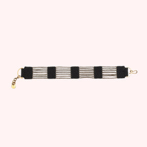 A 5 tier beaded bracelet made with black beads and antique brass chains. Handmade by A Nod To Design in Portland. OR.