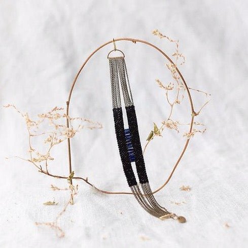 Ladder Bracelet made of black and lapis beds strung on antique brass chains. Handmade by A Nod To Design in Portland, OR.
