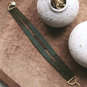Ladder Bracelet made with moss green and Afghani serpintine beads on antique brass chains. Handmade by A Nod To Design in Portland, OR.