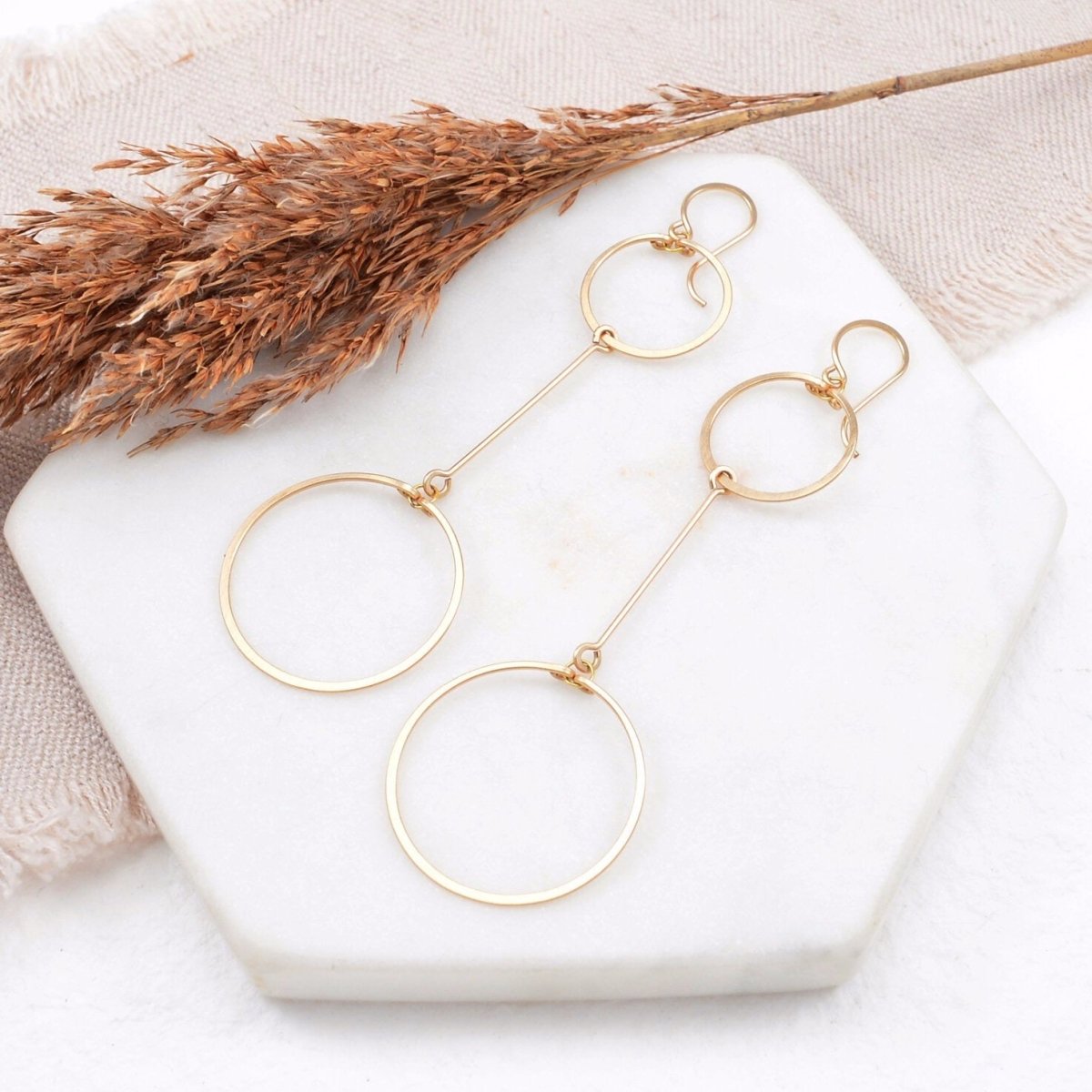 Two hand forged and hammered gold fill circles come together with a gold bar in between. Designed and handmade by Amy Olson in Portland, Oregon.