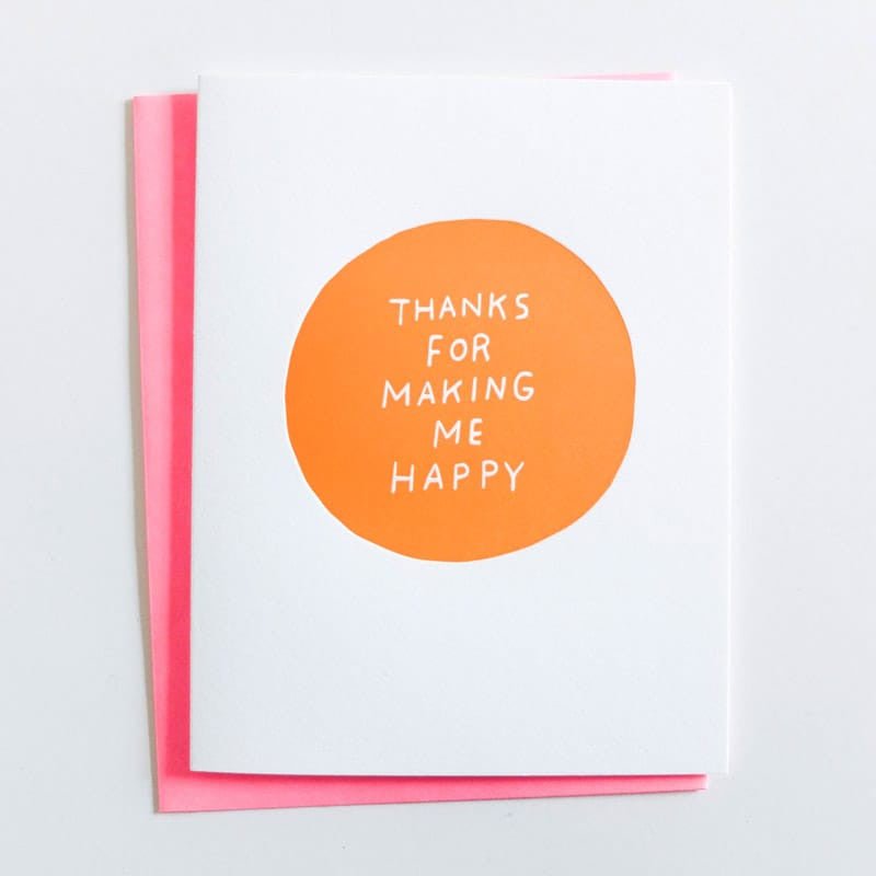 White card with a large orange circle in the center. Center of card reads: "THANKS FOR MAKING ME HAPPY" in white font. Designed by Ashkahn and printed in Portland, OR.