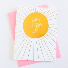 White card with iridescent yellow circular center and iridescent rays extending out. Center of card reads: "TODAY IS YOUR DAY." Comes with a pink envelope. Designed by Ashkahn and printed in Portland, OR.