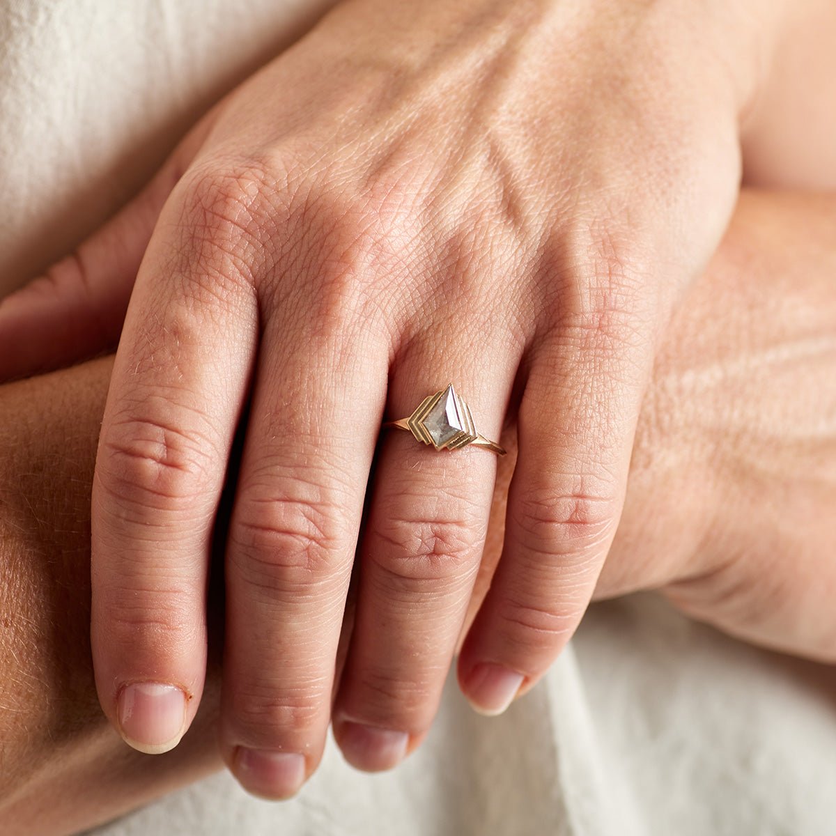 Model wears the Adra ring on their left hand. The Adra ring is kite-shaped with a salt & pepper diamond.