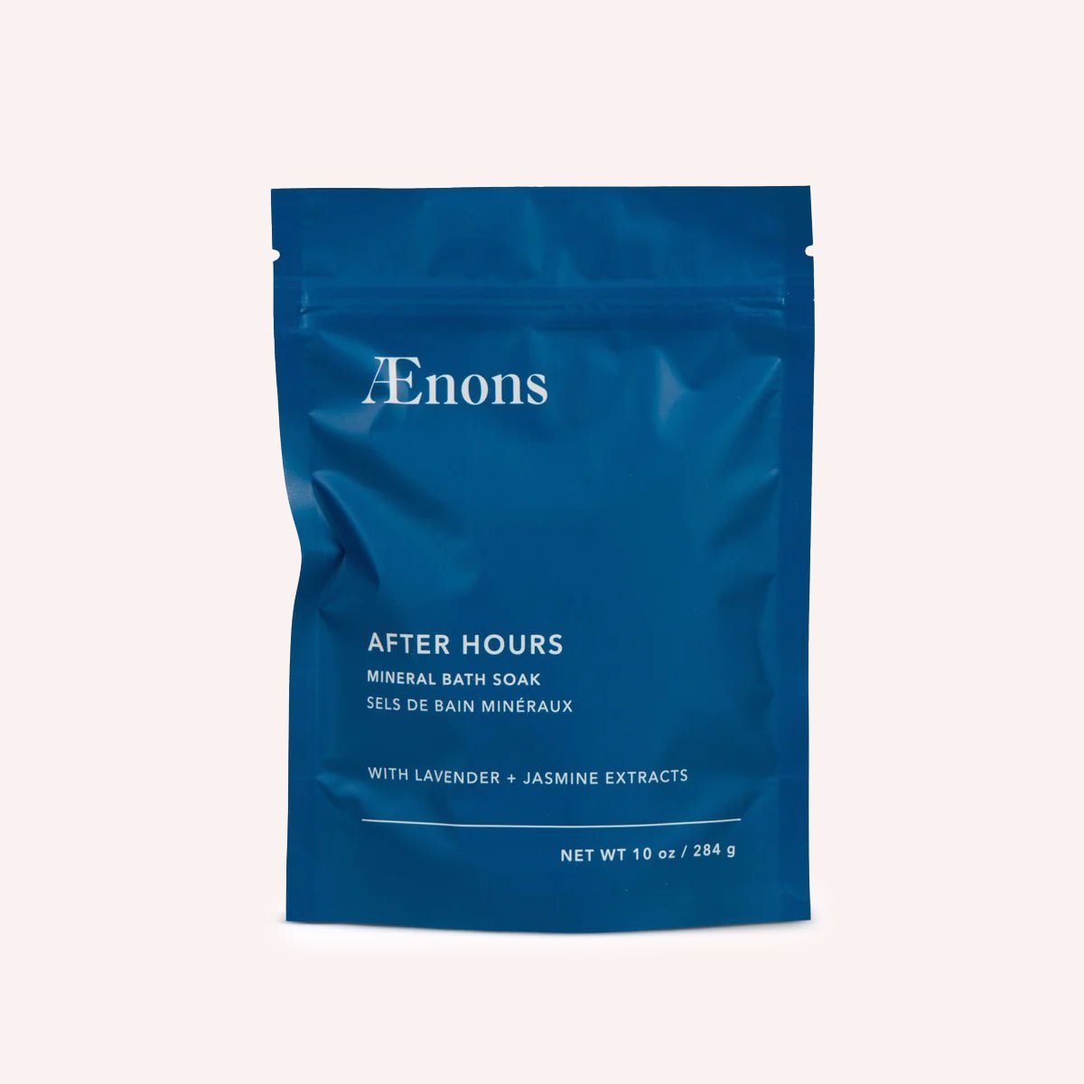 A bright blue package containing a mineral bath soak stands against a white background. The After Hours Mineral Bath Soak with Lavender + Jasmine Extracts is crafted by Aenons and made in Los Angeles, CA.