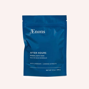 A bright blue package containing a mineral bath soak stands against a white background. The After Hours Mineral Bath Soak with Lavender + Jasmine Extracts is crafted by Aenons and made in Los Angeles, CA.