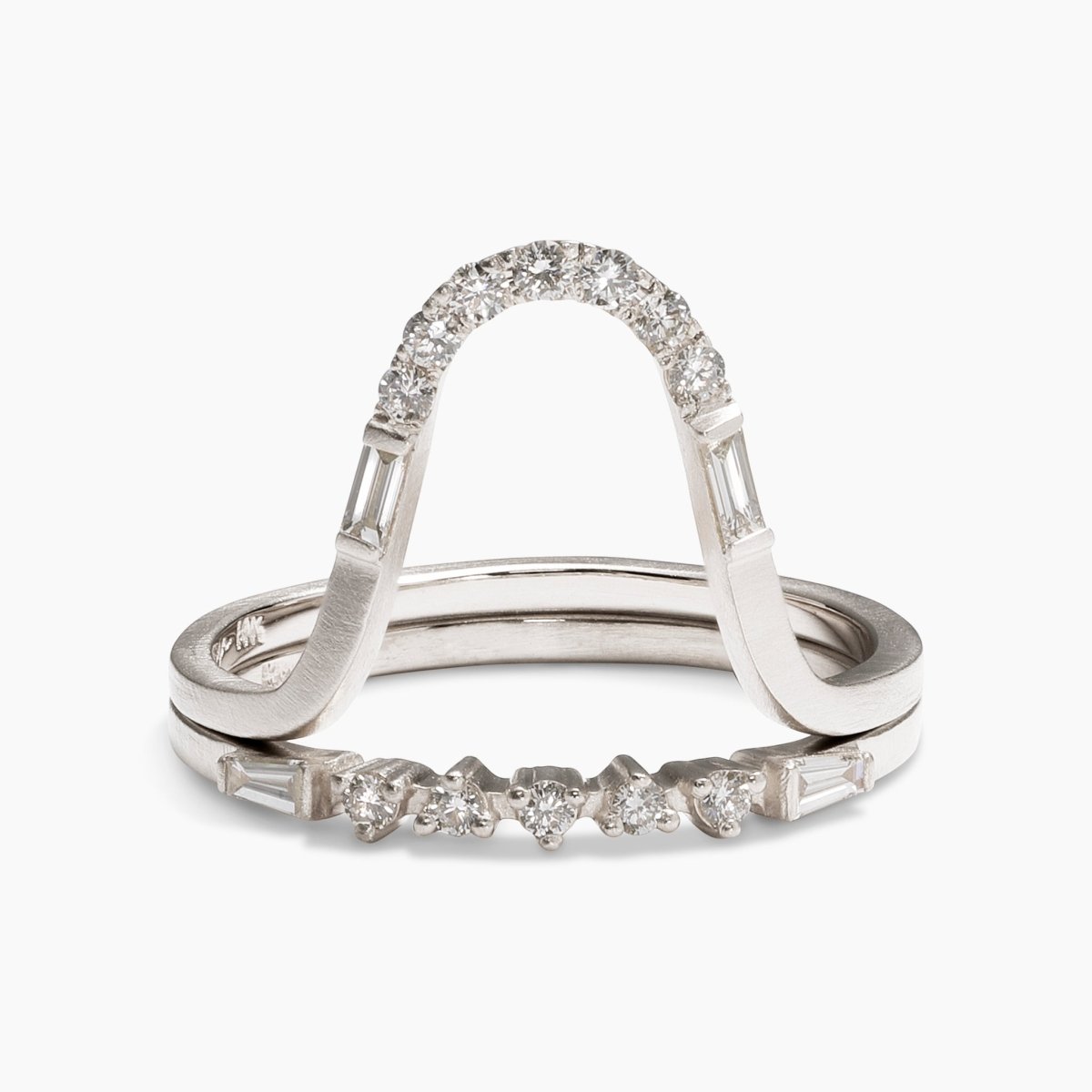 The Levo ring stacked on top of the Alma ring. Both feature baguette and brilliant cut round lab-grown diamonds in 14K white gold.