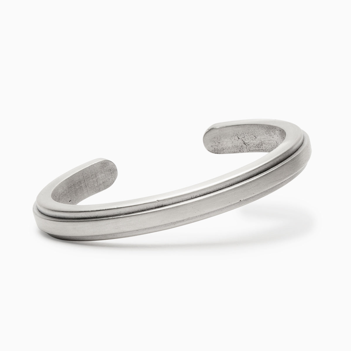 A squared off solid sterling silver cuff with an exterior band of bronze running down the center. The Amanca Cuff is designed and handcrafted in Portland, Oregon.