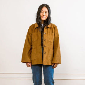 A model wears a tan corduroy jacket with front pockets and wide sleeves. The Angelica Jacket in Chestnut Cord is designed from Loup and made in New York City, USA.
