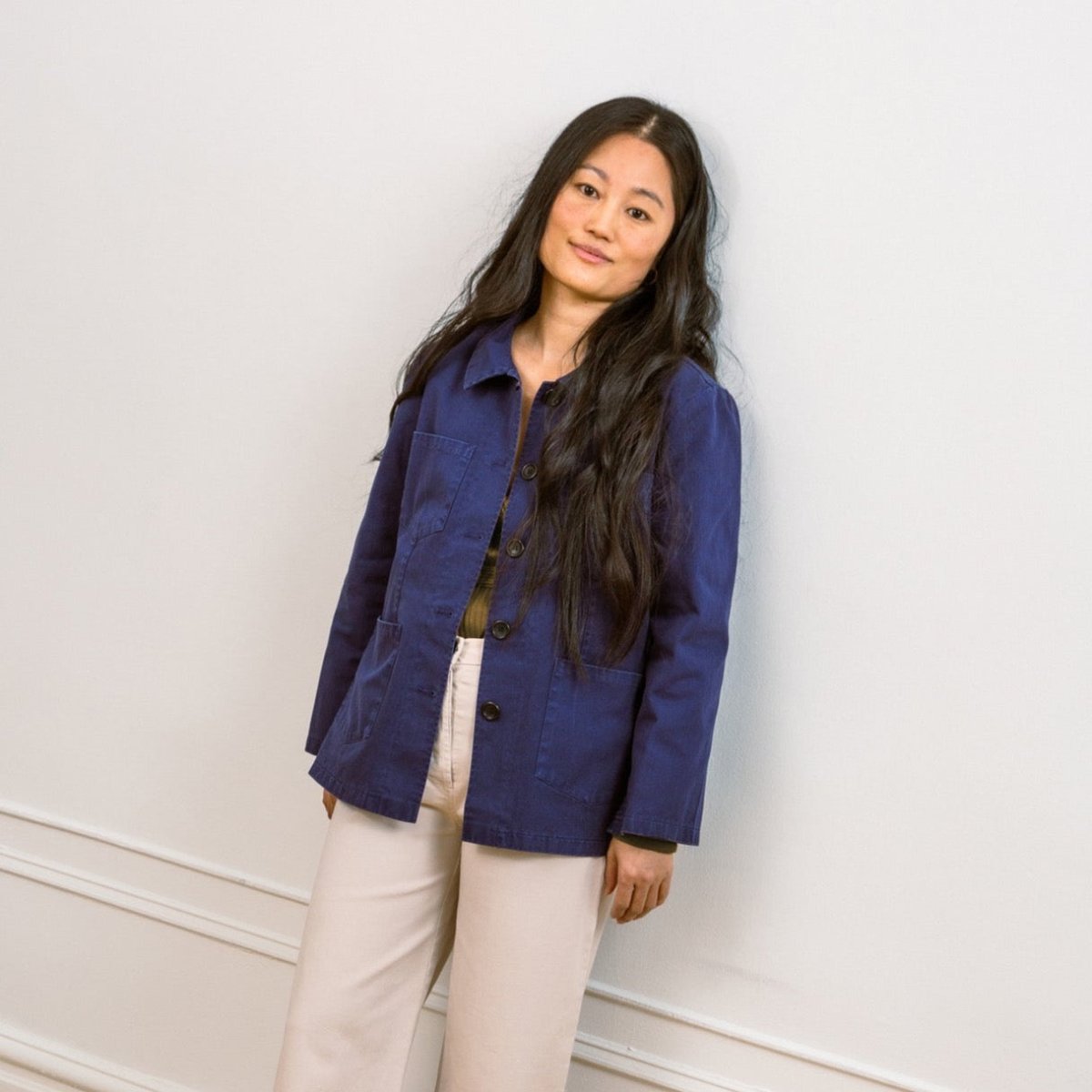 A model wears a blue chore jacket with front pockets and wide sleeves. The Angelica Jacket in Twilight is designed from Loup and made in New York City, USA.