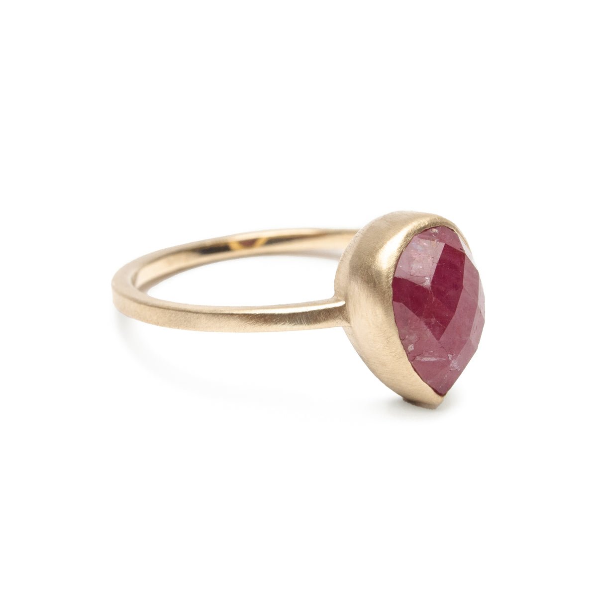 A conflict-free pear-shaped rose cut ruby set in a narrow 14k yellow gold band with a matte finish. The Pirum Ring is designed by Betsy & Iya and handcrafted in Portland, Oregon.