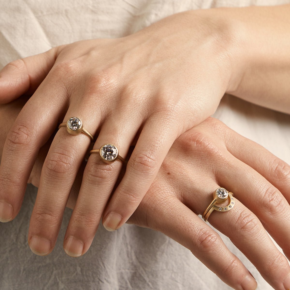 Model wears the Salire rings (left to right: 1.3 ct, 2 ct and 0.7 ct) and the Cor ring.