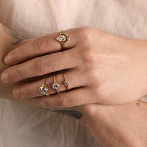 Model wears the Votum and Cor rings on their pointer finger. On their ring finger are the Sano rings (from left to right: 1.4 ct, 0.6 ct and 0.25 ct).
